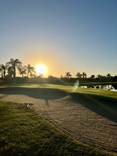 view of golf course at sunset