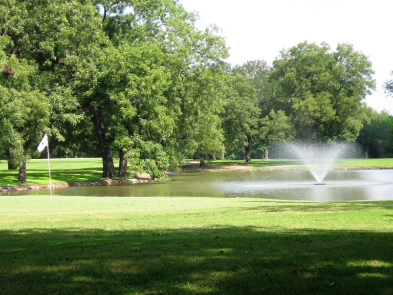 View of course hole with fountain in background.