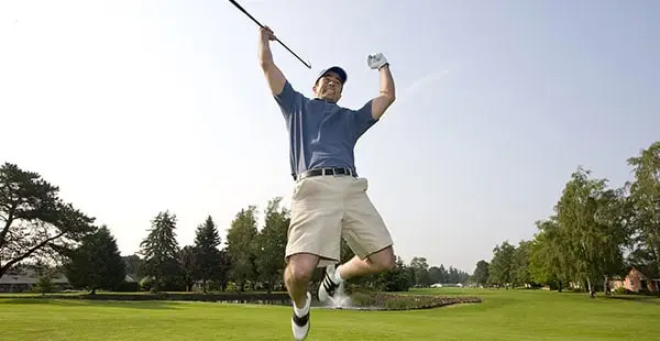 Golfer jumping for joy in the air 