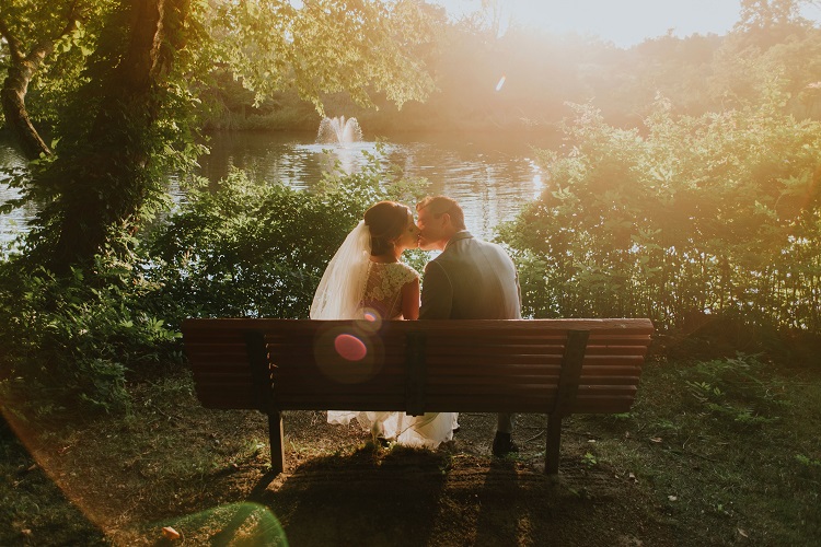 man and women kissing on bench