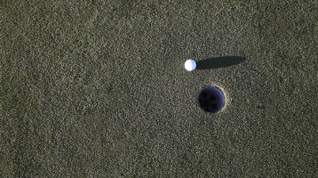 aerial view of golf ball near hole